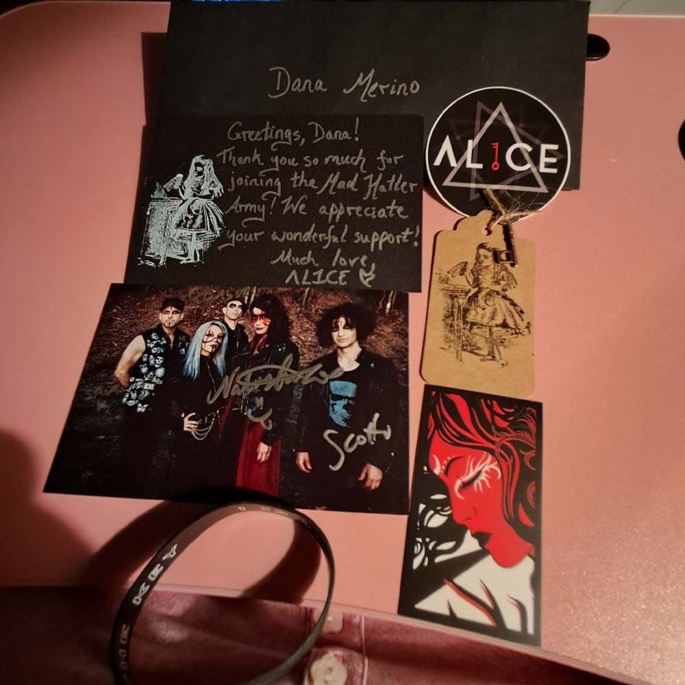 Dana's AL1CE starter pack contents - personalized note, stickers, key, wristband, and signed photo