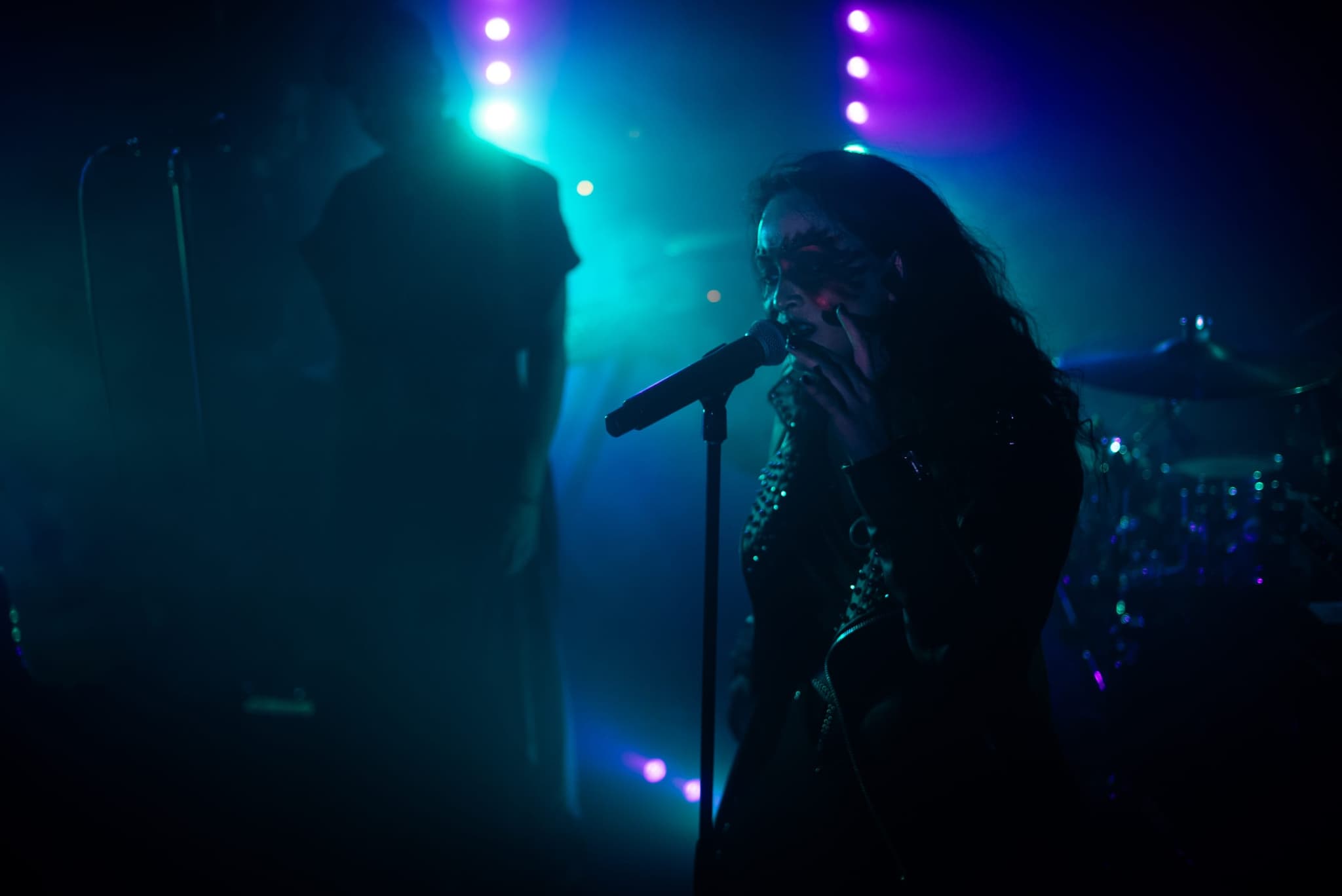 AL1CE vocalist performing live under blue and violet stage light
